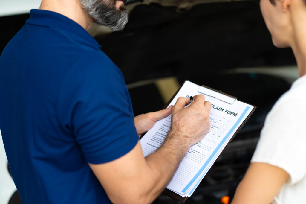 KFZ Gutachter Zentrale | car insurance concept insurance agent examine damaged car with woman customer write information report claim form KFZ Gutachter Zentrale